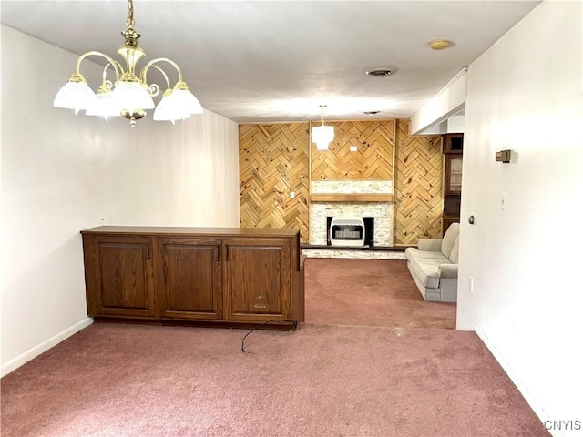 unfurnished living room with light carpet, an accent wall, a fireplace, and visible vents