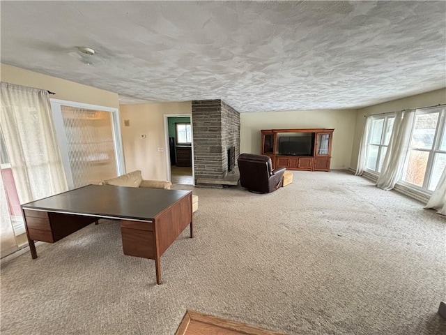 game room with carpet floors, a brick fireplace, and a textured ceiling