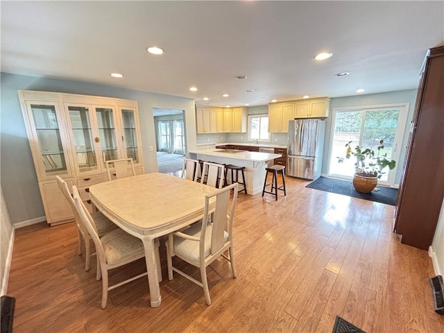 dining space featuring light wood finished floors, baseboards, and recessed lighting