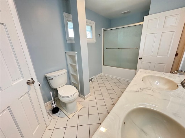 bathroom with shower / bath combination with glass door, toilet, a sink, baseboards, and tile patterned floors