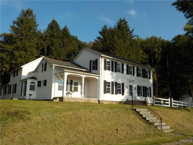 colonial house with covered porch and a front yard