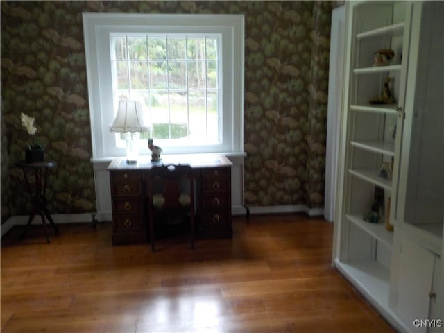 unfurnished room featuring wood finished floors and wallpapered walls