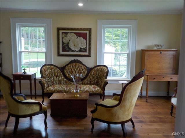 sitting room with crown molding, recessed lighting, a baseboard heating unit, wood finished floors, and baseboards