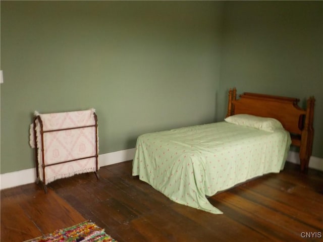 bedroom with baseboards and hardwood / wood-style flooring