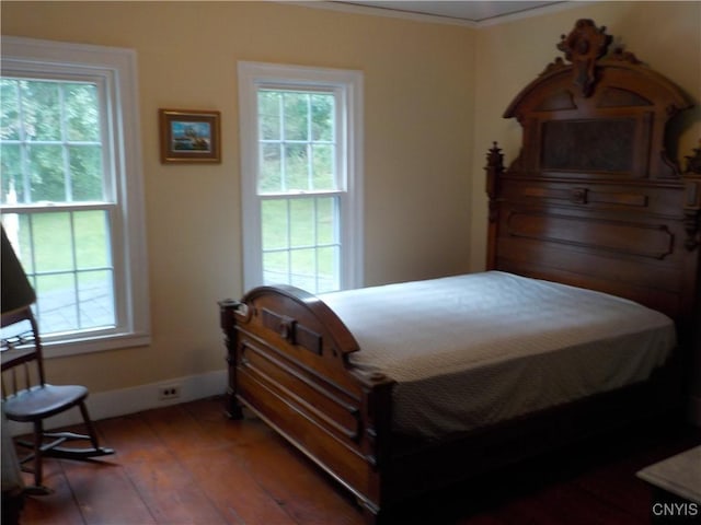 bedroom with crown molding, baseboards, and hardwood / wood-style floors