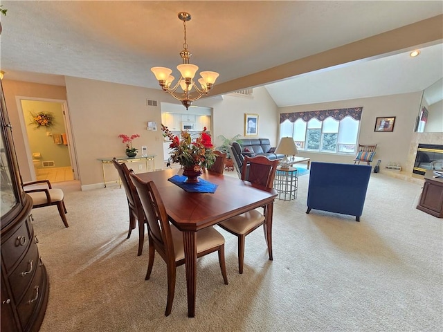 dining space featuring light carpet, vaulted ceiling, visible vents, and a notable chandelier