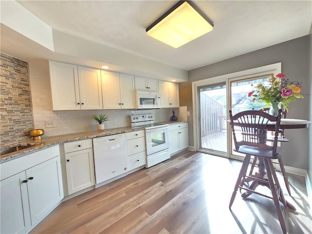 kitchen with white cabinets, white appliances, tasteful backsplash, and light wood-style flooring