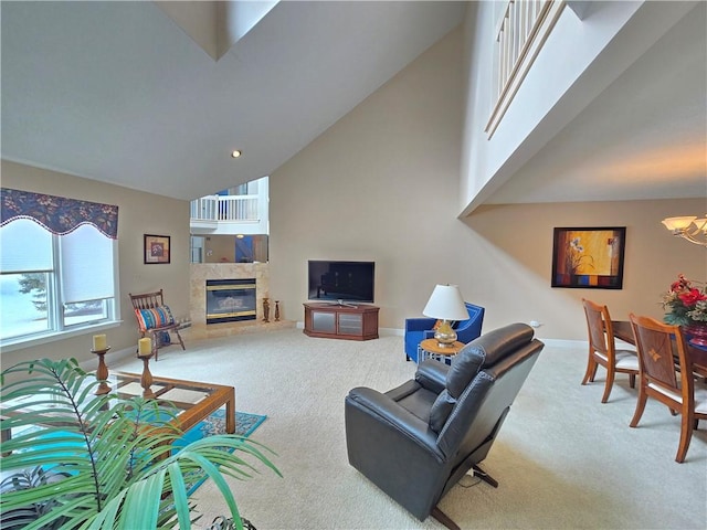 living room with carpet floors, baseboards, high vaulted ceiling, and a tile fireplace