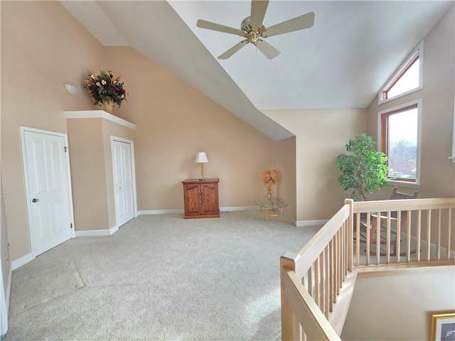 additional living space with carpet floors, high vaulted ceiling, ceiling fan, and baseboards