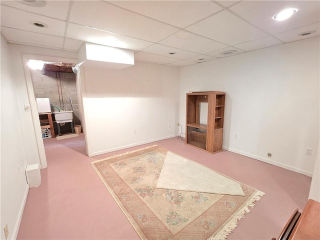 interior space featuring recessed lighting, a drop ceiling, a sink, and baseboards