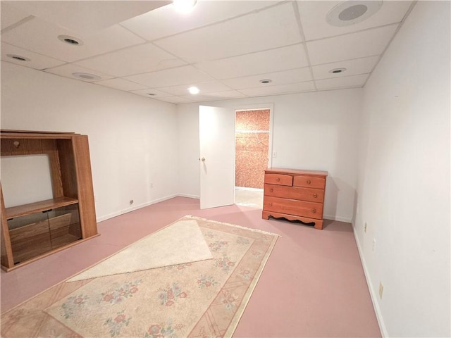 carpeted spare room with a paneled ceiling and baseboards