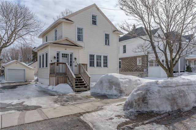 view of front facade featuring driveway, an outdoor structure, and a detached garage