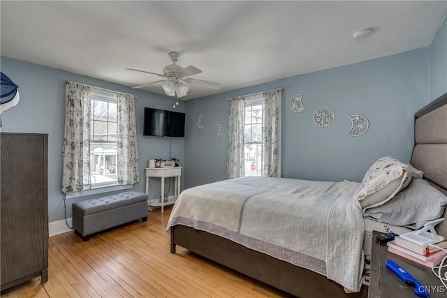 bedroom with baseboards, hardwood / wood-style flooring, and a ceiling fan