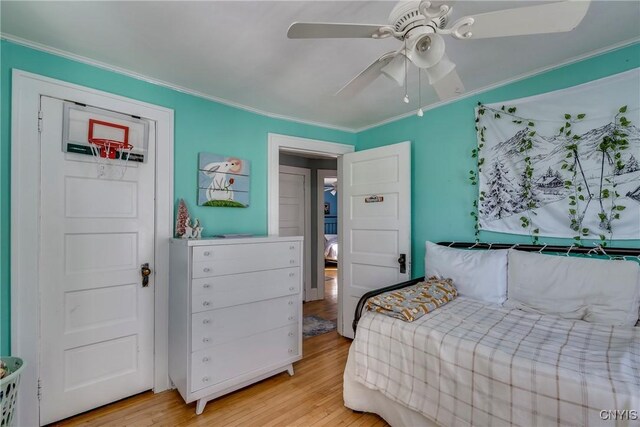 bedroom with ceiling fan, crown molding, and wood finished floors