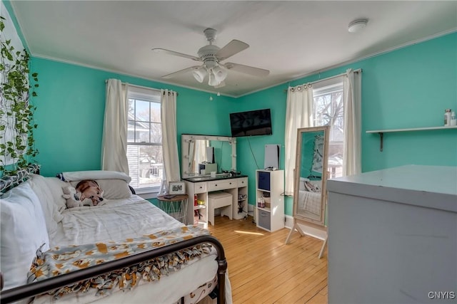 bedroom with wood-type flooring, multiple windows, ornamental molding, and ceiling fan