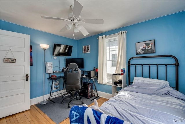 bedroom featuring ceiling fan, wood finished floors, and baseboards