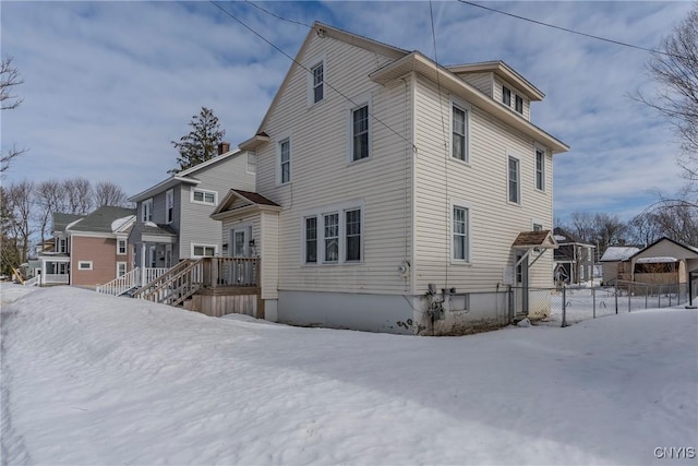 view of snowy exterior featuring fence