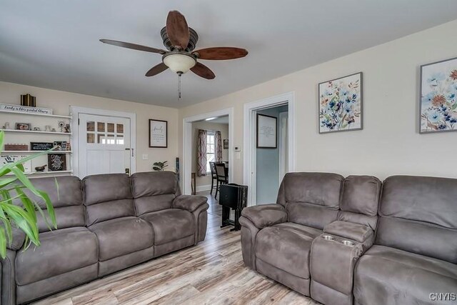 living area with light wood finished floors and a ceiling fan