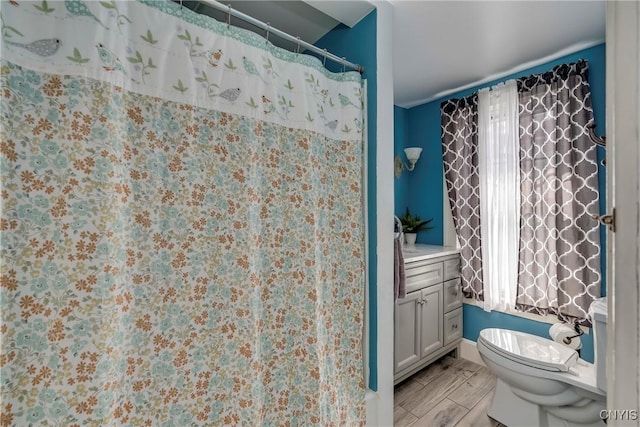 full bath with a shower with shower curtain, vanity, toilet, and wood tiled floor