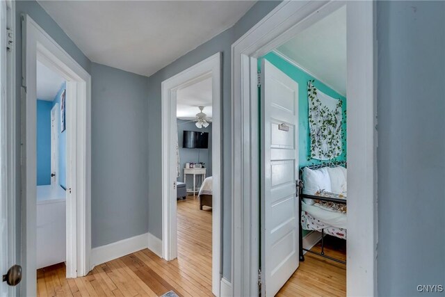 hall with light wood finished floors and baseboards