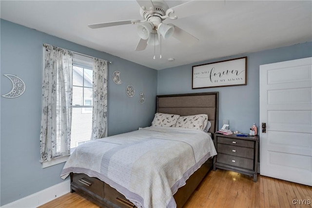 bedroom featuring wood finished floors, a ceiling fan, and baseboards