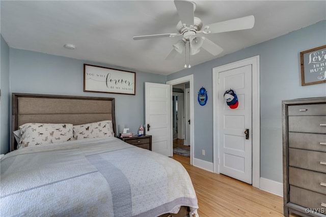 bedroom featuring ceiling fan, light wood-type flooring, and baseboards