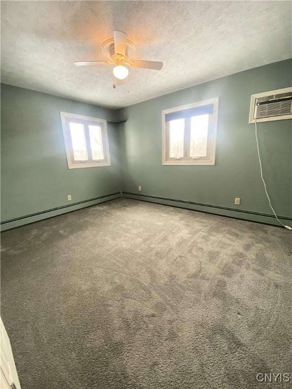 empty room with carpet floors, ceiling fan, a textured ceiling, and a wall mounted AC