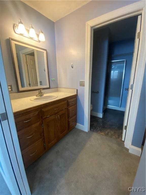 bathroom with baseboards, vanity, and toilet