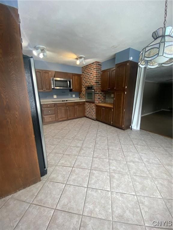 kitchen with light tile patterned floors, appliances with stainless steel finishes, and light countertops