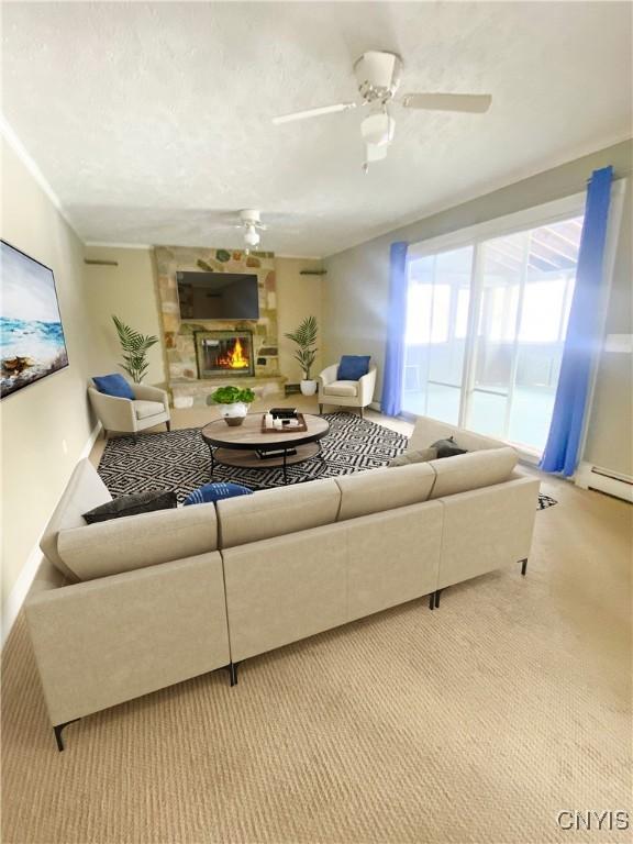 carpeted living room featuring a textured ceiling, a fireplace, baseboards, and a ceiling fan