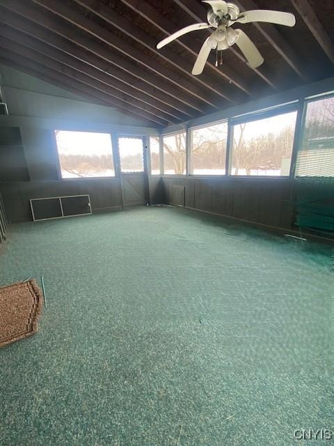 unfurnished sunroom with vaulted ceiling with beams, ceiling fan, and visible vents