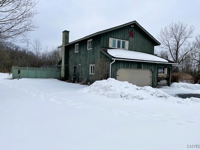 exterior space featuring an attached garage and a chimney