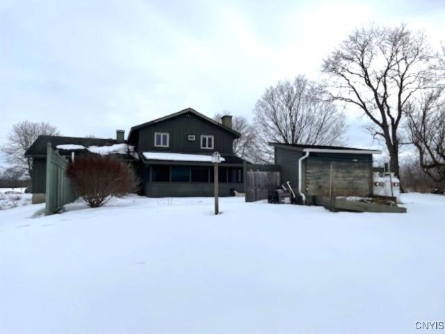 view of snow covered back of property