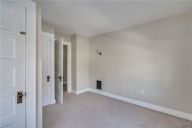 unfurnished room featuring baseboards and light colored carpet