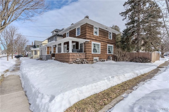 snow covered property featuring fence