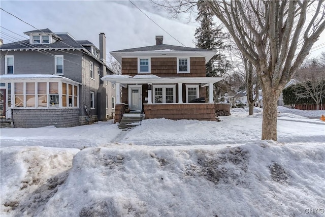 american foursquare style home with a chimney and a sunroom