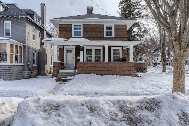 traditional style home featuring a chimney and a porch