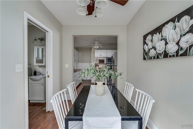 dining room featuring wood finished floors, a ceiling fan, and baseboards