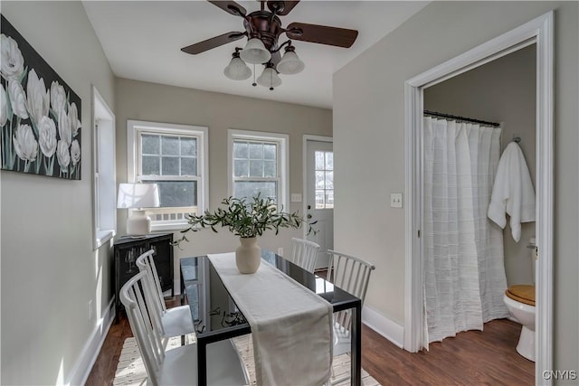 dining space featuring ceiling fan, baseboards, and wood finished floors