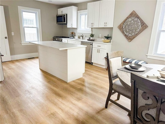 kitchen featuring light wood-style floors, appliances with stainless steel finishes, and light countertops