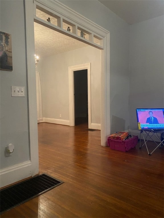 interior space featuring visible vents, baseboards, and wood finished floors