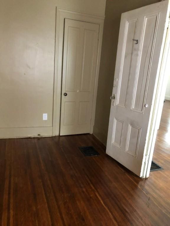 unfurnished bedroom with visible vents, baseboards, and wood finished floors