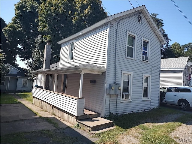 view of front of property featuring covered porch and a chimney