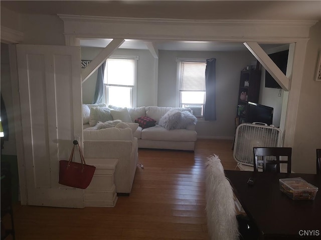 living area with crown molding, baseboards, and wood finished floors