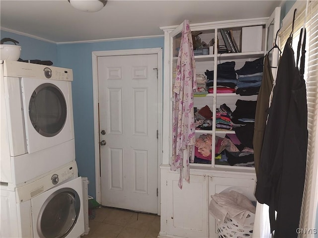 clothes washing area featuring crown molding, laundry area, stacked washing maching and dryer, and tile patterned floors