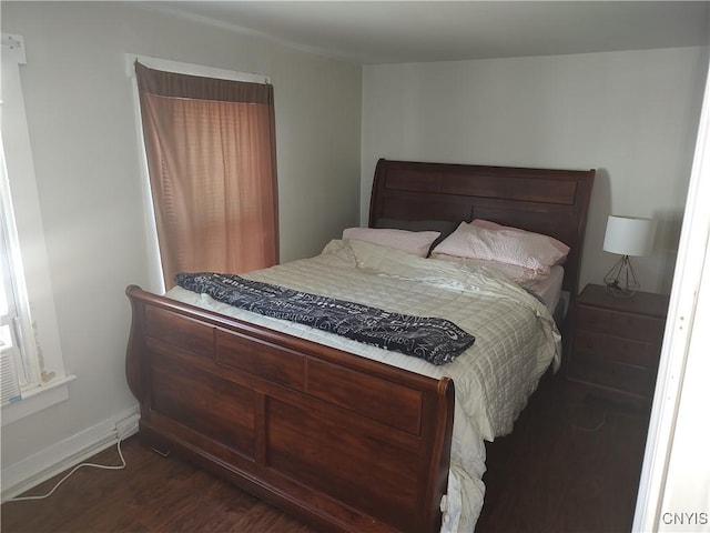 bedroom with dark wood-style flooring and baseboards