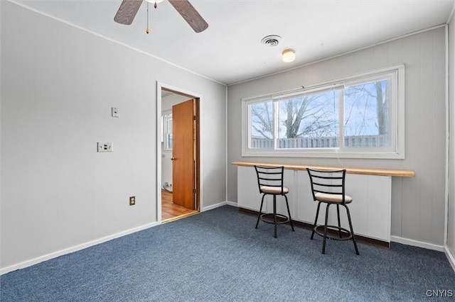 unfurnished dining area with carpet, visible vents, ceiling fan, and baseboards