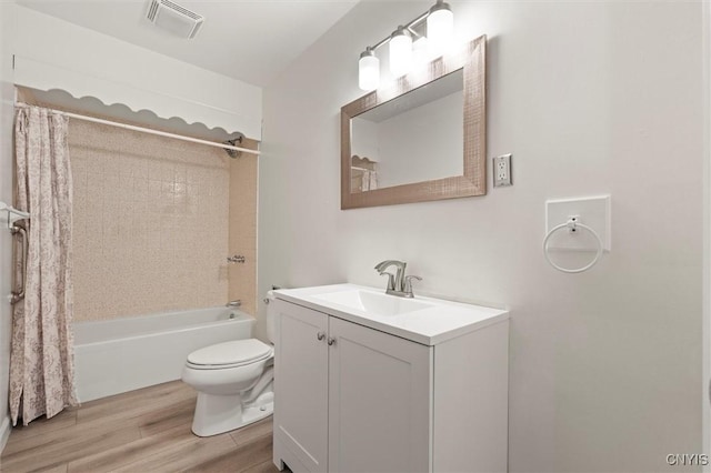 bathroom featuring shower / tub combo, visible vents, toilet, wood finished floors, and vanity