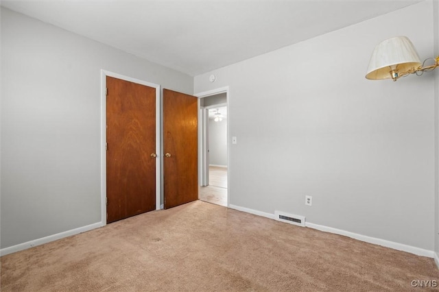 unfurnished bedroom featuring carpet, visible vents, and baseboards