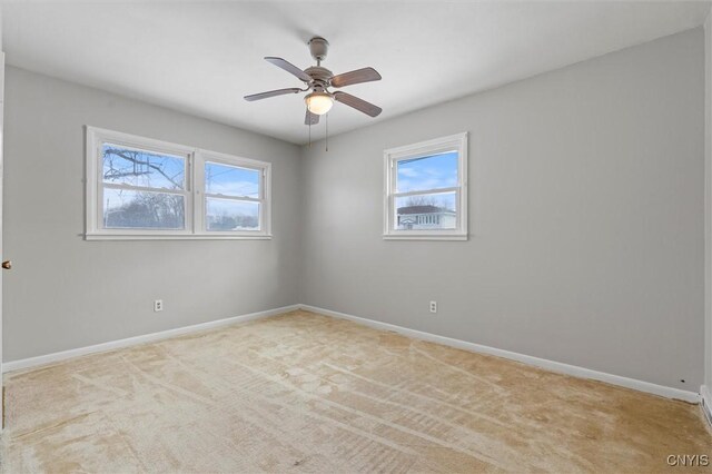 unfurnished room featuring carpet floors, baseboards, and a ceiling fan